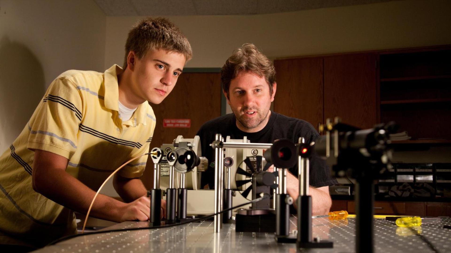 Two people working on an engineering project together at a table